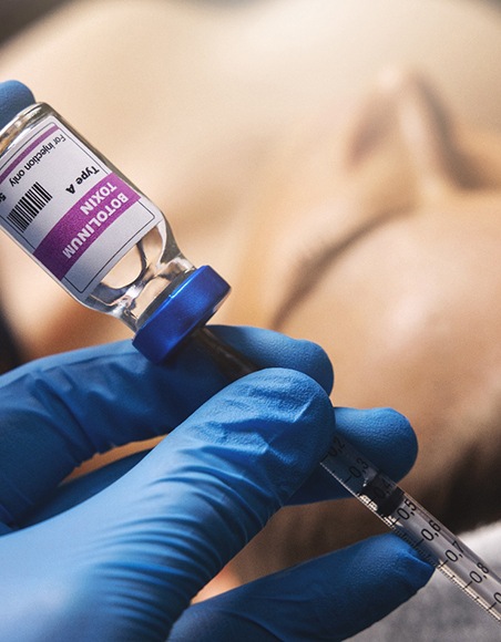 a person extracting BOTOX out of a vial