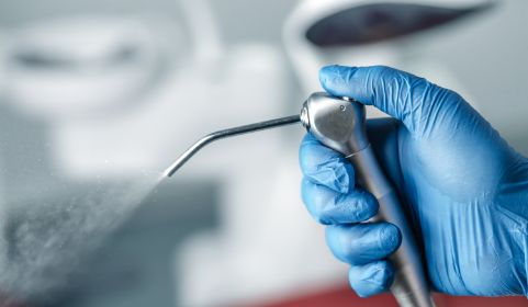 Holding Airflow instrument for polishing teeth