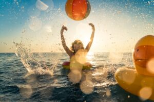 Woman playing with beach ball in the water. 