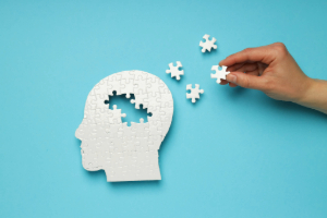 Taking pieces out of puzzle of head to represent memory loss.